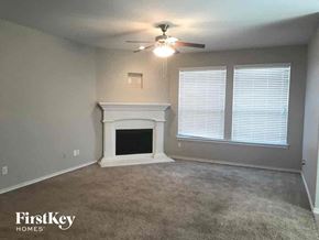 Weatherford house for rent - A living room with a fireplace and a ceiling fan.