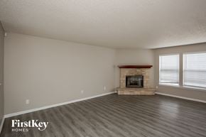 Fishers house for rent - A room with a fireplace and wooden floors.