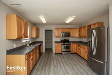 Fishers house for rent - A kitchen with wooden cabinets and a stainless steel refrigerator.
