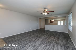 Queen Creek house for rent - an empty living room with a ceiling fan and a window