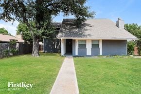 Plano house for rent - a blue house with a lawn and a tree