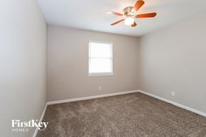 Plano house for rent - a bedroom with carpet and a ceiling fan