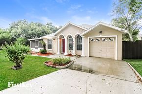 Deltona house for rent - a white house with a driveway and a garage door