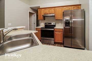 Deltona house for rent - a kitchen with stainless steel appliances and wooden cabinets