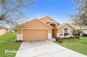Orlando house for rent - a beige house with a driveway and a garage door