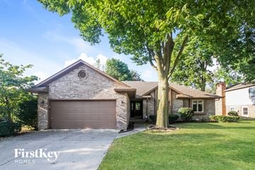 Indianapolis house for rent - a brick house with a garage and a tree