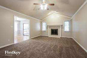 Indianapolis house for rent - an empty living room with a fireplace and a ceiling fan