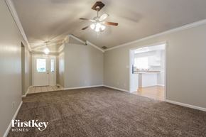 Indianapolis house for rent - an empty living room with a ceiling fan and a rug