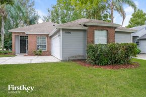 Jacksonville house for rent - a small brick house with a yard and a garage door