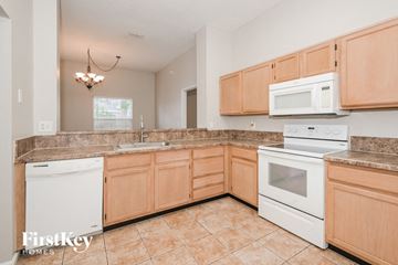 Jacksonville house for rent - a large kitchen with white appliances and wooden cabinets