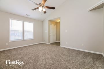 Knightdale house for rent - a spacious living room with carpet and a ceiling fan