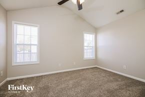 Knightdale house for rent - a bedroom with carpet and two windows and a ceiling fan