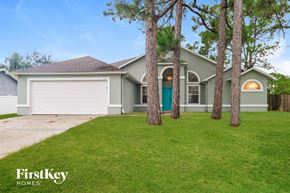 Palm Bay house for rent - A house with a green lawn and trees in front of it.