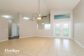 Palm Bay house for rent - A spacious room with a ceiling fan and a large window.