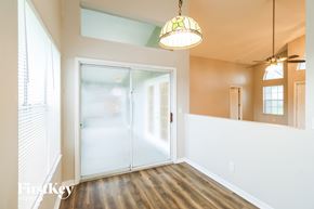 Palm Bay house for rent - A room with a wooden floor and a stained glass hanging light.