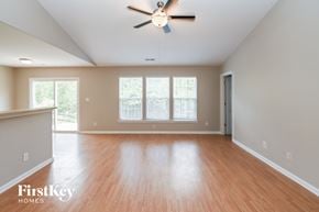 Charlotte house for rent - an empty living room with wood floors and a ceiling fan