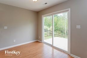 Charlotte house for rent - an empty living room with a large window and wood flooring
