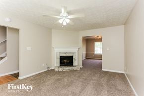 Marietta house for rent - A living room with a fireplace and a ceiling fan.
