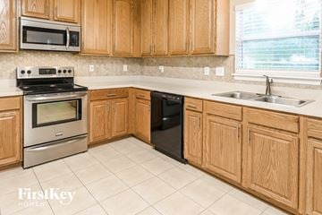 Jacksonville house for rent - A kitchen with wooden cabinets and a stainless steel oven.