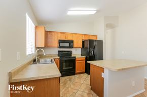 Tolleson house for rent - a kitchen with black appliances and wooden cabinets