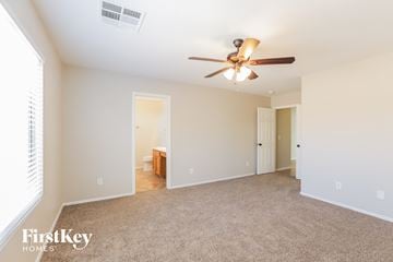 Tolleson house for rent - a spacious living room with a ceiling fan and a carpet