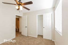 Tolleson house for rent - a bedroom with a ceiling fan and a door to a bathroom