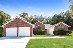 Ellenwood house for rent - a brick house with a white garage door and a lawn