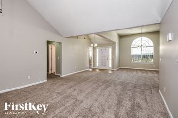 Ellenwood house for rent - a spacious living room with carpet and a large window