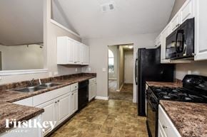 Ellenwood house for rent - a kitchen with white cabinets and black appliances and granite counter tops