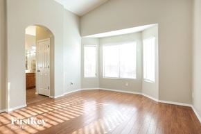 Tucson house for rent - an empty living room with wood floors and windows