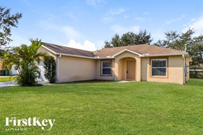 Port St Lucie house for rent - a house with a lawn and a palm tree