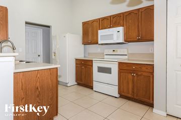 Port St Lucie house for rent - a kitchen with white appliances and wooden cabinets