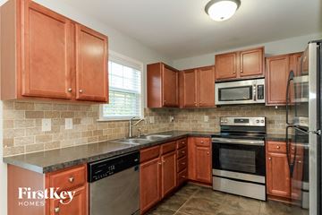 Winston Salem house for rent - a kitchen with wooden cabinets and stainless steel appliances