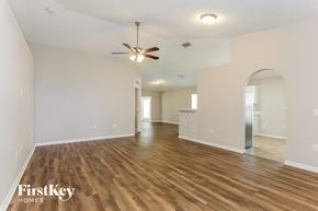 Jacksonville house for rent - the living room and dining room with hardwood flooring and a ceiling fan