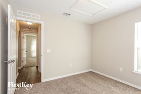 Jacksonville house for rent - a bedroom with white walls and carpet and a door to a hallway