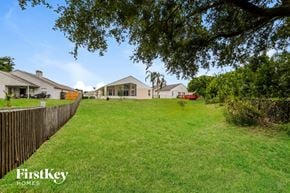 Winter Haven house for rent - A grassy area with a fence and houses in the background.