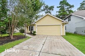 Spring house for rent - A two-car garage is attached to a house with a yellow siding.