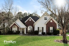 Covington house for rent - front view of a home with white and red brick and black roof
