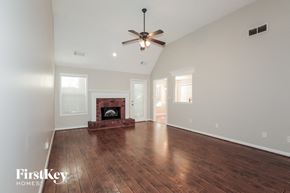 Covington house for rent - a living room with a ceiling fan and a fireplace