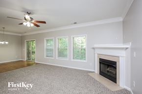 Ball Ground house for rent - a living room with a fireplace and a ceiling fan