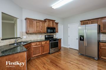 Ball Ground house for rent - a kitchen with wooden cabinets and stainless steel appliances