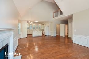 Douglasville house for rent - an open kitchen and living room with wood floors and a fireplace
