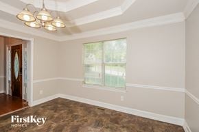 Douglasville house for rent - an empty dining room with a window and a chandelier