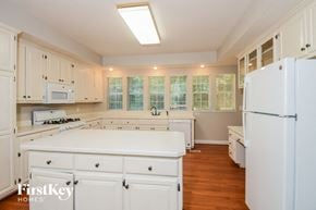 Douglasville house for rent - a kitchen with white cabinets and white appliances and a white counter top