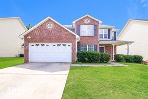 Jackson house for rent - A house with a red brick exterior and a white garage door.