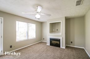 Jackson house for rent - A living room with a fireplace and a ceiling fan.