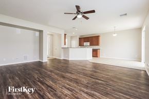 Riverview house for rent - an empty living room with a ceiling fan and a kitchen