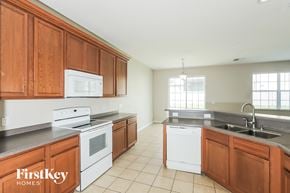 Riverview house for rent - a large kitchen with white appliances and wooden cabinets