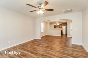 Charlotte house for rent - A spacious room with wooden floors and a ceiling fan.