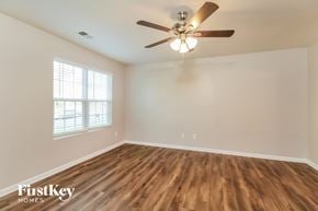 Charlotte house for rent - A room with a ceiling fan and wooden flooring.